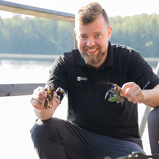 Christian håller upp nyfångade kräftor