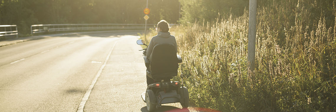 Permobil kör på en trottoar